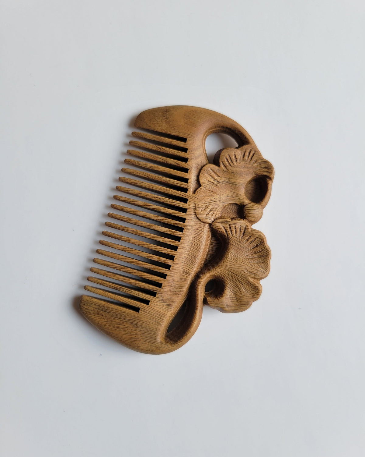 Ginkgo leaf carving close-up — flowing fan-shaped motif, hand carved Green Sandalwood comb, fine tooth detangling comb