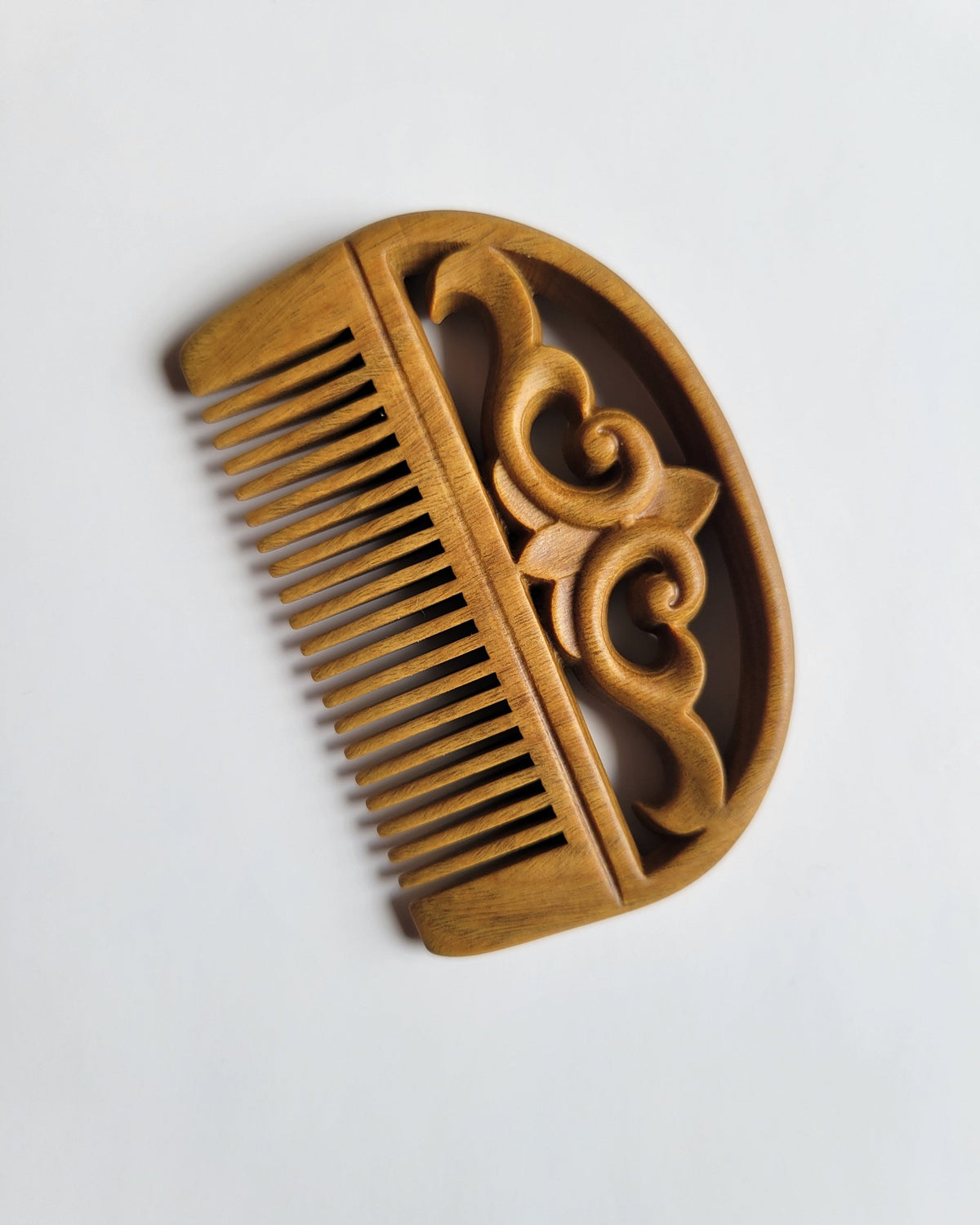 Reverse side cloud carving detail — open lattice Green Sandalwood comb, hand carved flowing lines, fine tooth pocket comb