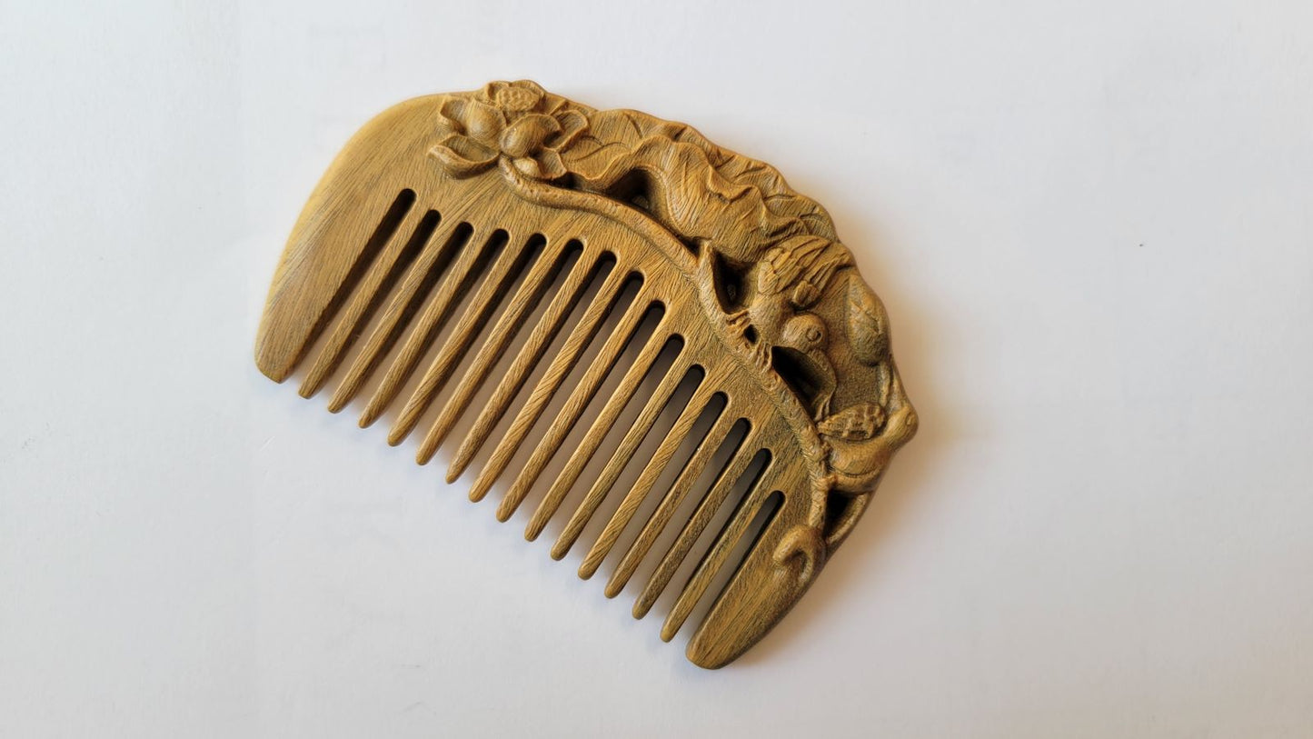 Green sandalwood mini comb angled view, hand-carved egret perched among lotus blooms, Yi Lu Lian Ke auspicious motif