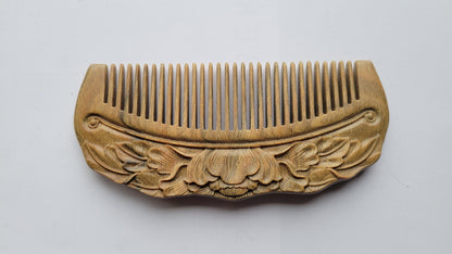 Blooming lotus with leaves hand carved in relief on Green Sandalwood comb, flat lay showing front face carving detail — Arakicrafts