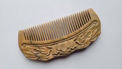 Close-up of lotus flower and leaf relief carving on Green Sandalwood comb — artisan hand carved detail — Arakicrafts
