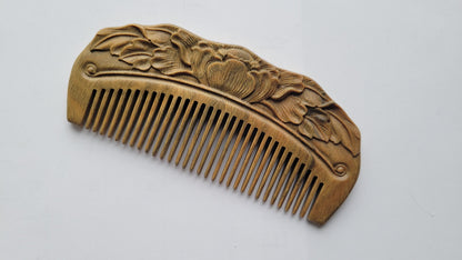 Rounded edge and fine teeth of hand carved Green Sandalwood lotus comb, flat lay side angle — Arakicrafts