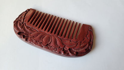 A purple heart wood comb with intricate lotus flower carvings. The comb has a curved shape and fine teeth. A perfect and unique gift for her!