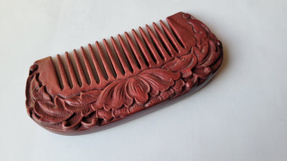 Decorative wooden comb with lotus flower carvings. It is made of purple heart wood and has beautiful color and wood grain.