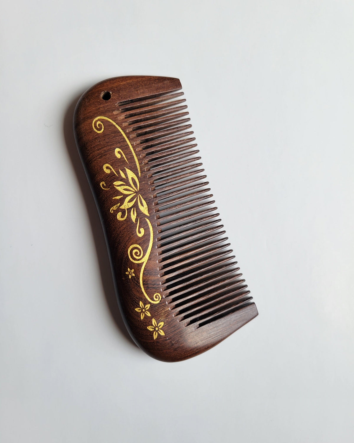 Aiko Lotus Wood Comb front view — dark brown Sucupira wood with gold hand-painted lotus design, fine tooth comb gift for her