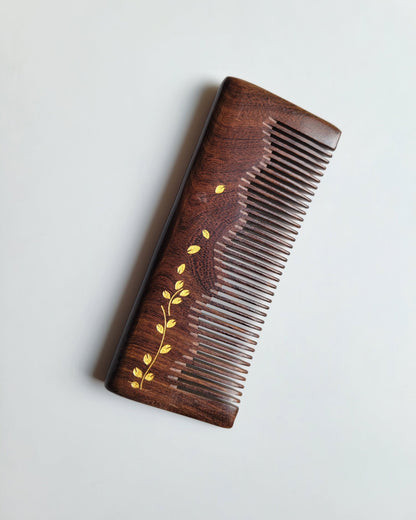 Dark chocolate Sucupira wood grain comb — gold ivy leaf motif, overhead flat lay, fine tooth detangling