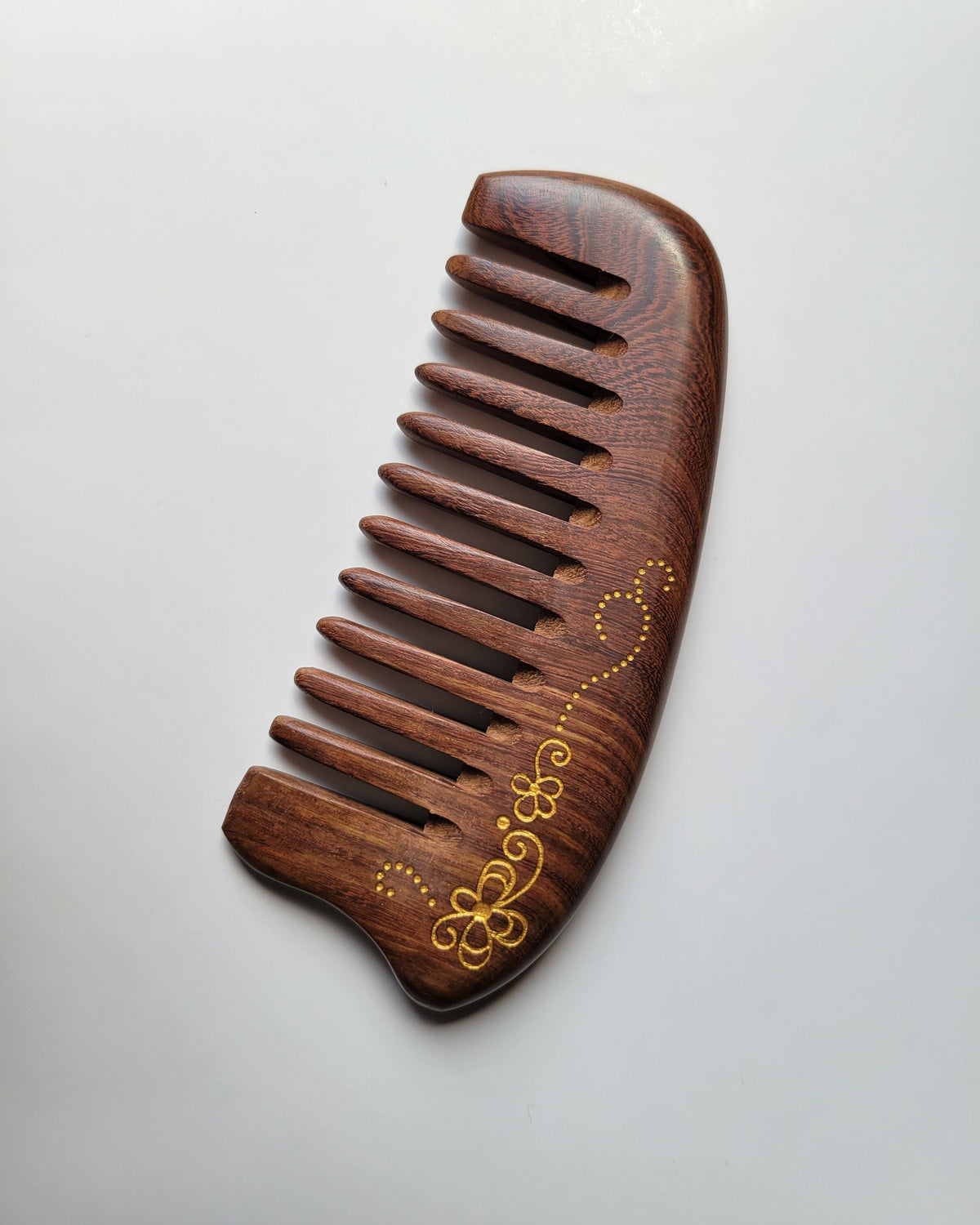 Sucupira wood wide tooth comb flat lay, gold floral scroll painting, extra wide 0.45 cm teeth for thick curly and long hair Hand-painted. Comes with drawstring gift bag, birthday, Mother's Day, and Valentine's Day gift for her