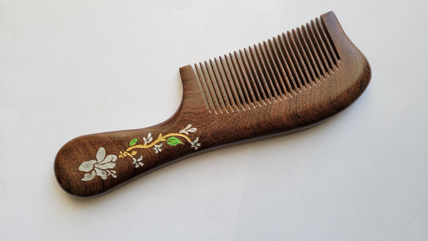 Close-up of white magnolia flower, green leaves, and gold accent detail hand painted on wood comb handle — Arakicrafts. It is design for hair grooming and all hair type. 