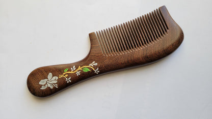 Close-up of white magnolia flower, green leaves, and gold accent detail hand painted on wood comb handle — Arakicrafts. It is design for hair grooming and all hair type. 