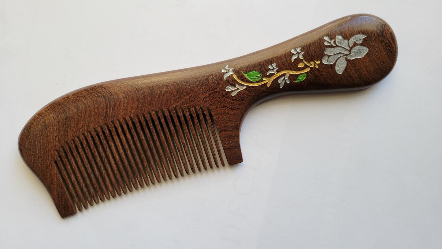 Handcrafted wood comb with magnolia motif, flat lay angled view showing single-piece hardwood grain — Arakicrafts