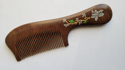 Handcrafted wood comb with magnolia motif, flat lay angled view showing single-piece hardwood grain — Arakicrafts