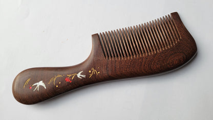 Dark brown Sucupira wood fine tooth comb with ornate painted handle, flat lay side angle — Arakicrafts