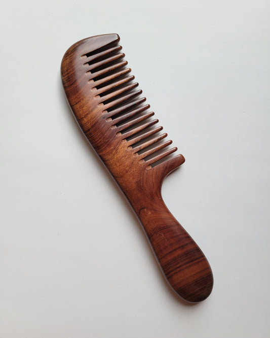 Rich reddish brown Mopane hardwood comb with natural black stripe grain, flat lay overhead view — Arakicrafts