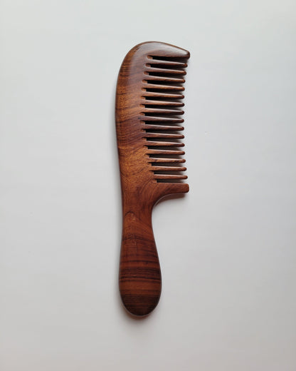 Single-piece African Mopane wood comb, flat lay angled view highlighting grain and stripe pattern — Arakicrafts