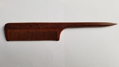 A long, thin, wooden comb with a pointed handle. The comb is made of dark brown pau rosa wood and has fine teeth.  it is designed for precision sectioning and hair styling.
