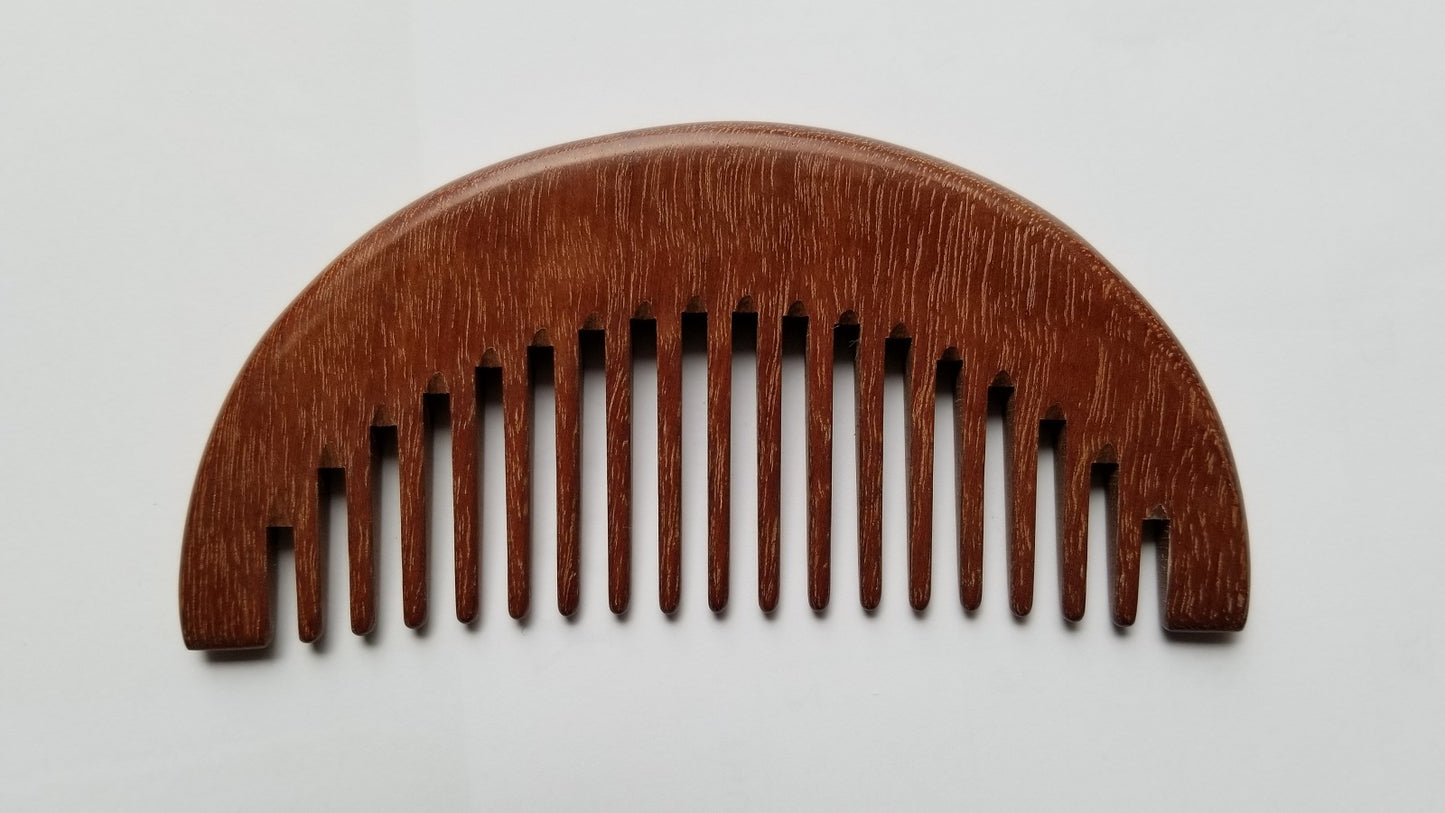 A wooden comb with a curved top and evenly spaced teeth. The comb is made of a reddish-brown wood and has a smooth, polished finish. The teeth are wide and evenly spaced, designed for detangling hair.