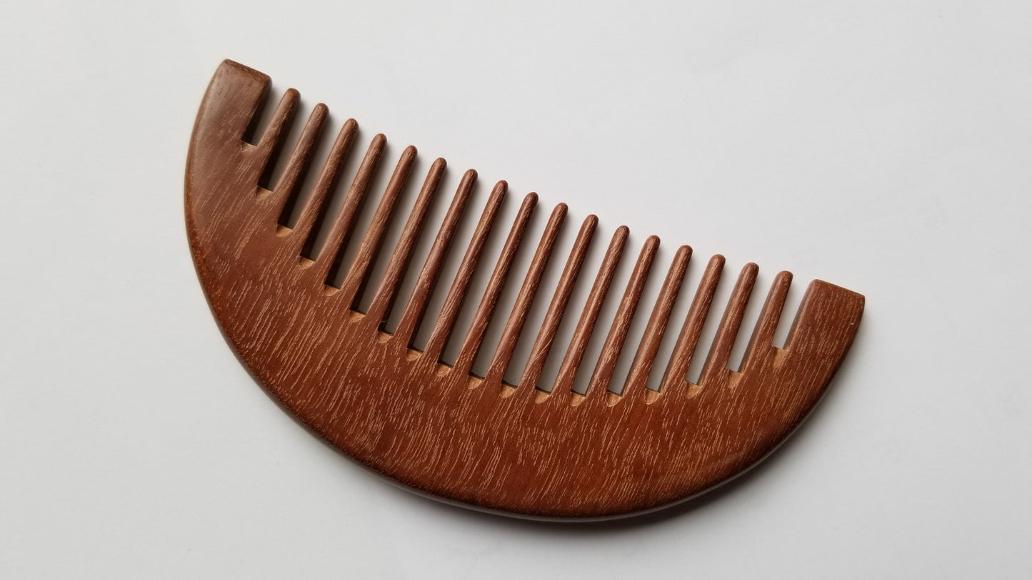 A wooden comb with a curved design. The comb is made of a dark brown pau rosa wood and has evenly spaced teeth. The comb is designed for hair care and grooming.  Gift for her and comes with fabric gift bag. 