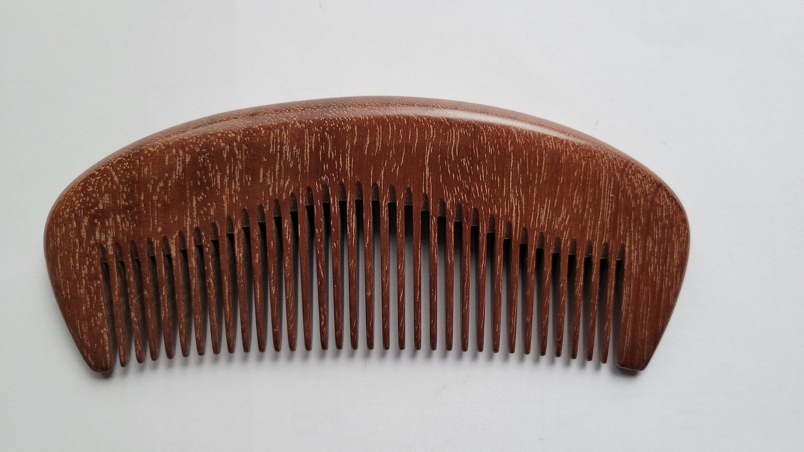 Pau Rosa wood pocket comb with curved handle, flat lay front view — Arakicrafts