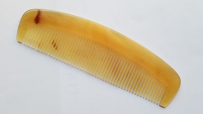 A vintage style curved comb made of sheep horn. The comb has fine teeth and a smooth, polished surface. It helps to reduce static and distributes hair oil naturally. 