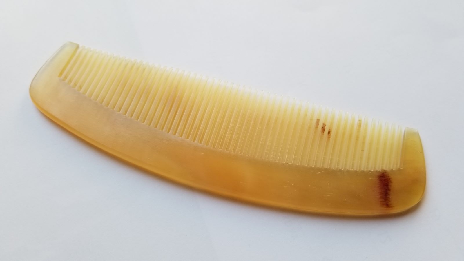A vintage style curved comb made of sheep horn. The comb has fine teeth and a smooth, polished surface. It helps to reduce static and distributes hair oil naturally. Unique Gift for father's Day