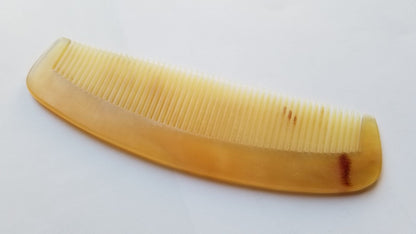 A vintage style curved comb made of sheep horn. The comb has fine teeth and a smooth, polished surface. It helps to reduce static and distributes hair oil naturally. Unique Gift for father's Day