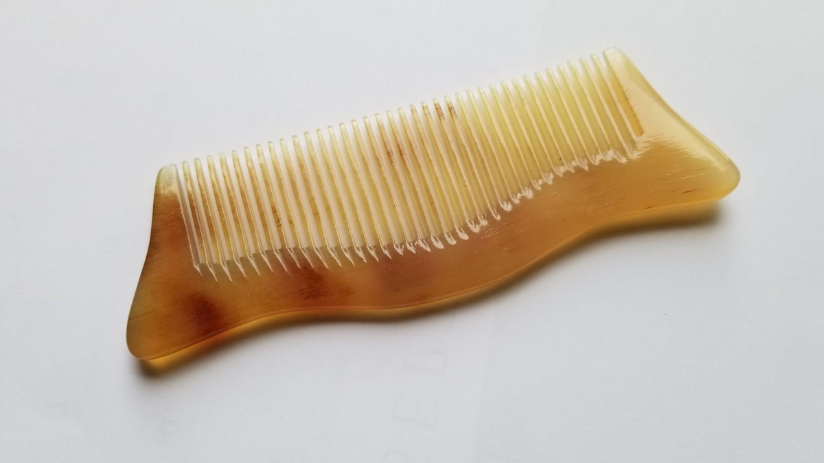 Araki sheep horn comb showing natural color variation — light amber tone