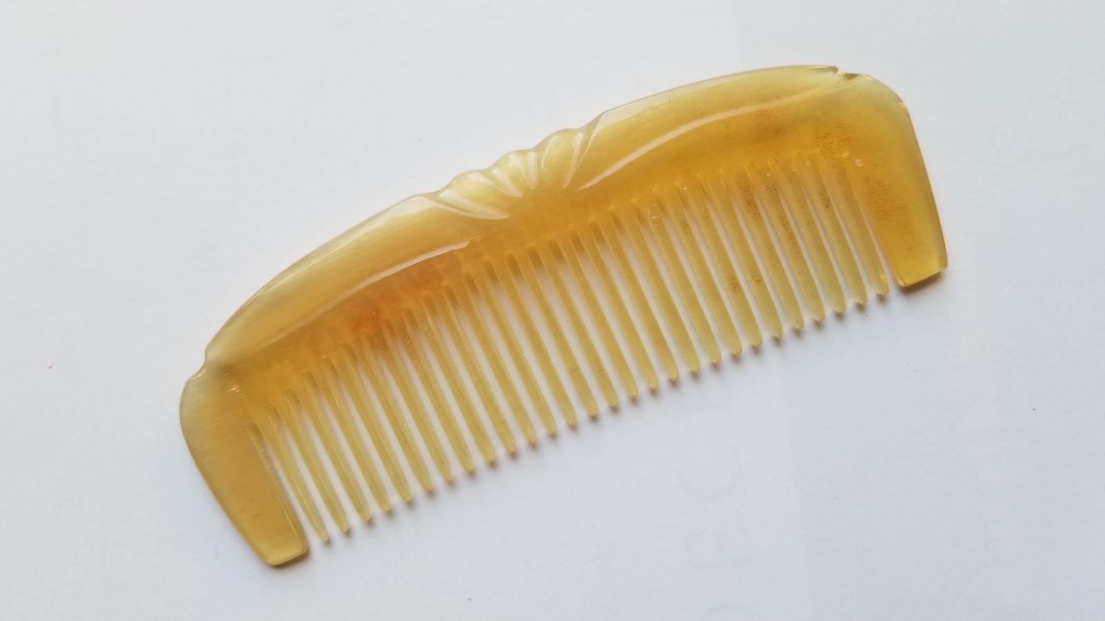 Translucent pale yellow to golden honey sheep horn comb, flat lay overhead showing natural tone variation — Arakicrafts