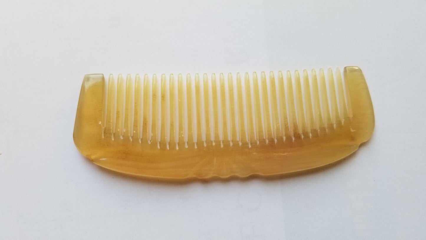Smooth curved spine of Art Deco sheep horn comb, flat lay side angle showing translucency and natural horn depth — Arakicrafts