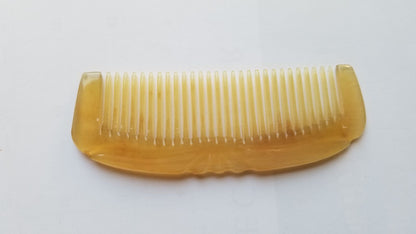 Smooth curved spine of Art Deco sheep horn comb, flat lay side angle showing translucency and natural horn depth — Arakicrafts