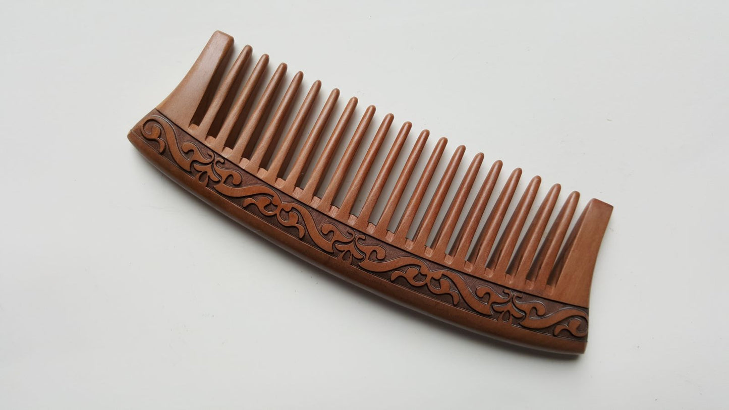 vintage style peach wood wooden comb with a carved karakusa design. The comb has evenly spaced wide teeth and can massage the scalp while you comb the hair daily. 
