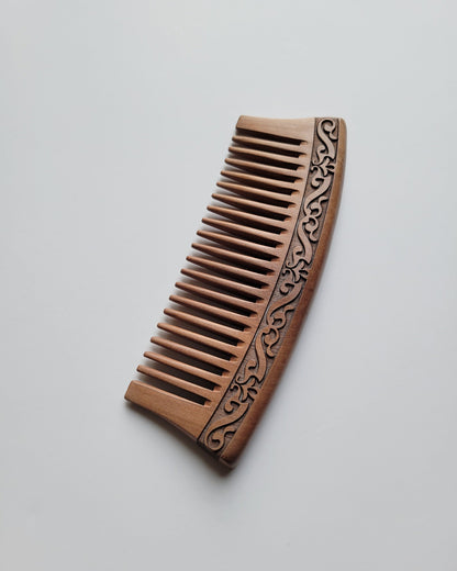 vintage style peach wood wooden comb with a carved karakusa design. The comb has evenly spaced wide teeth and can detangle the curly hair and beard for your daily hair care routine. 