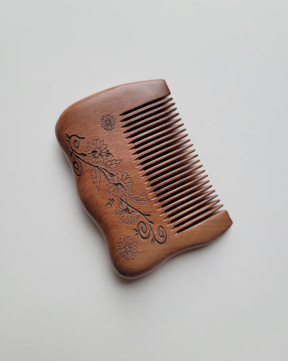 Fine-tooth peach wood comb with 0.15 cm tooth spacing for fine hair grooming, shown diagonally with carved flowers along the grip. good for short and fine hair