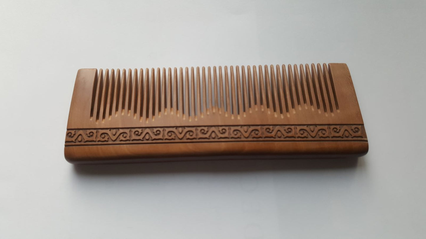 Natural peach wood hair comb overhead view, Greek meander carving, anti-static grooming tool for fine hair