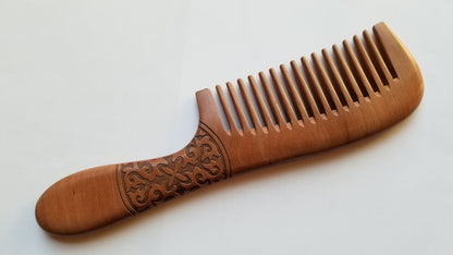 Warm brown peach wood comb with natural finish, flat lay overhead showing full length and carved handle — Arakicrafts