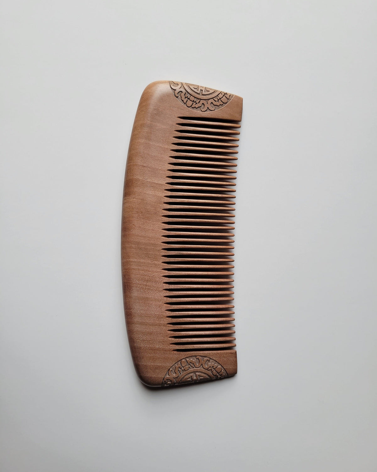 A Classic Peach Wood Comb showing its smooth curved spine and rounded edges. Gift for new boyfriend. 
