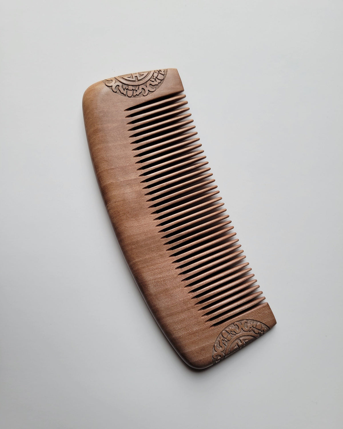Peach wood grooming comb with evenly spaced teeth and 1.5 mm distance.  Great beard and hair grooming tool for men.