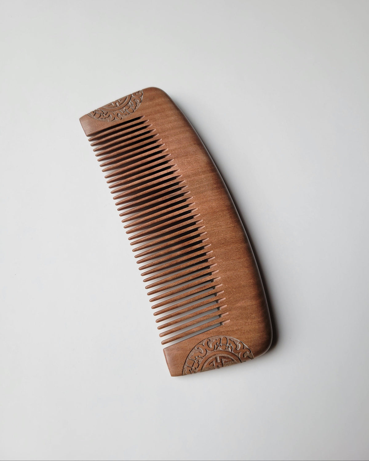 Classic carved wood comb for everyday grooming, showing rounded tooth tips and decorative end patterns. Great stocking stuffers for men for holidays.