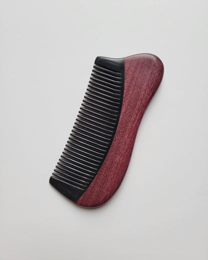 Dark red Purple Heart wood comb with black buffalo horn teeth, flat lay showing fine tooth detail — Arakicrafts