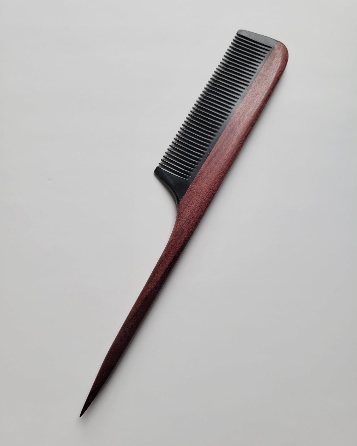 Purple heart wood rat tail comb back view, natural reddish-brown grain detail, hand-inlaid construction, single-piece artisan hair comb