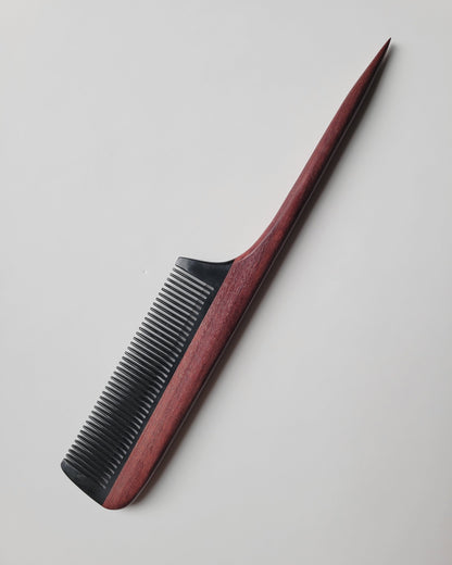 Hand-inlaid rat tail comb angled view, purple heart wood handle with natural grain, buffalo horn fine teeth for snag-free combing
