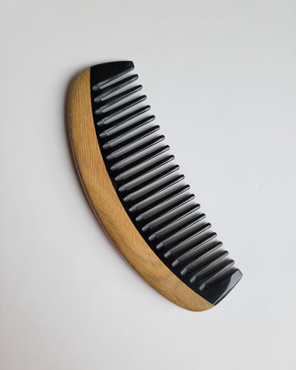 Classic Sandalwood Wide Teeth Horn Comb flat lay — side angle highlighting hand-inlaid buffalo horn teeth and sandalwood grain