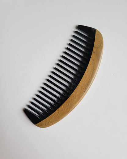 Classic Sandalwood Wide Teeth Horn Comb flat lay — side angle highlighting hand-inlaid buffalo horn teeth and sandalwood grain