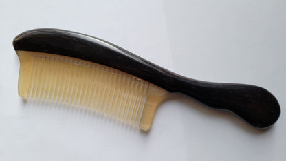 comb with a near black wooden handle. The teeth of the comb is make of ram horn.   A collector piece for hair lovers and great gift idea.