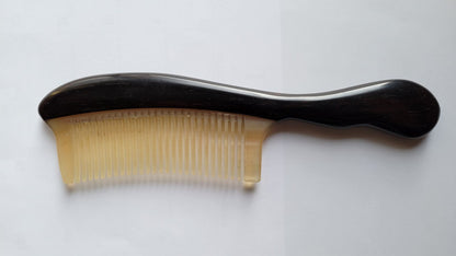 comb with a near black long curved wooden handle. The teeth of the comb is make of ram horn.   A collector piece for hair lovers and great gift idea for all.