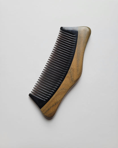 Anti-static buffalo horn beard comb for men, flat lay overhead view — Arakicrafts.  The comb has a curved, ergonomic shape, and is designed for grooming hair.