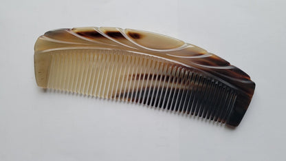 A brown and beige tortoiseshell comb with a curved handle and fine teeth.  A gift for all item for special occasion.