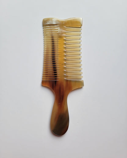Overhead view of a double-sided Yak Horn comb with wide and fine teeth