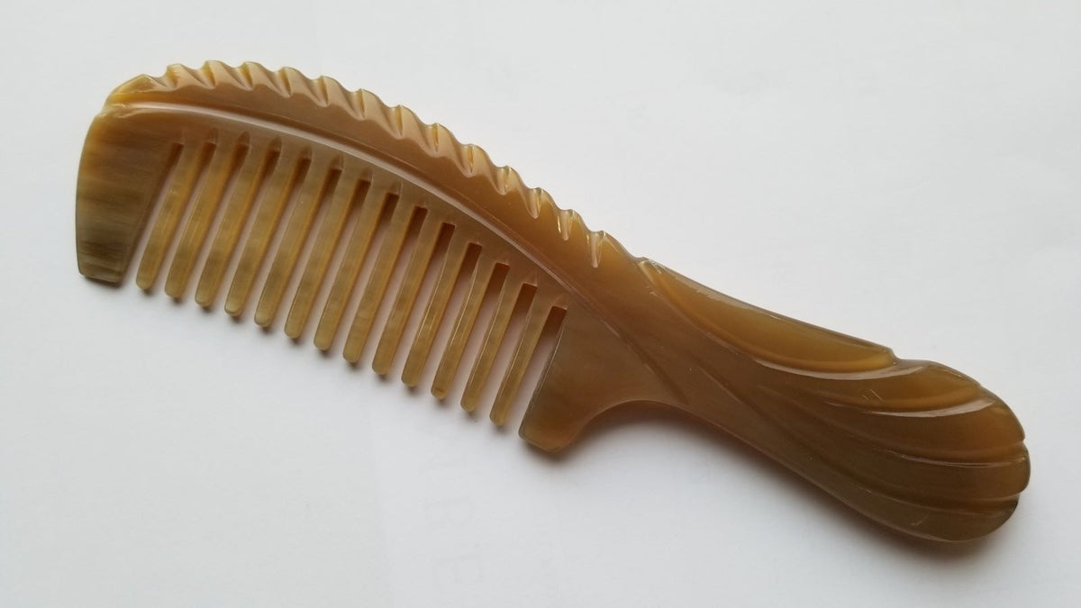 Brown natural yak horn comb with curved silhouette, flat lay overhead view — Arakicrafts