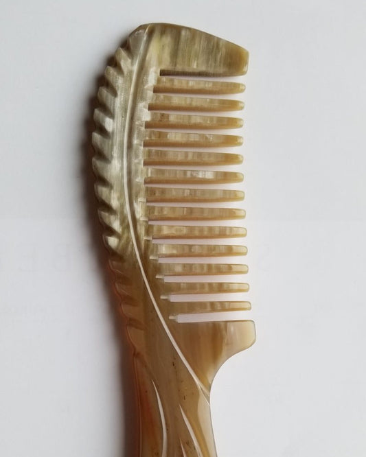 Carved flowing lines on flat wide yak horn comb handle, flat lay detail shot — Arakicrafts