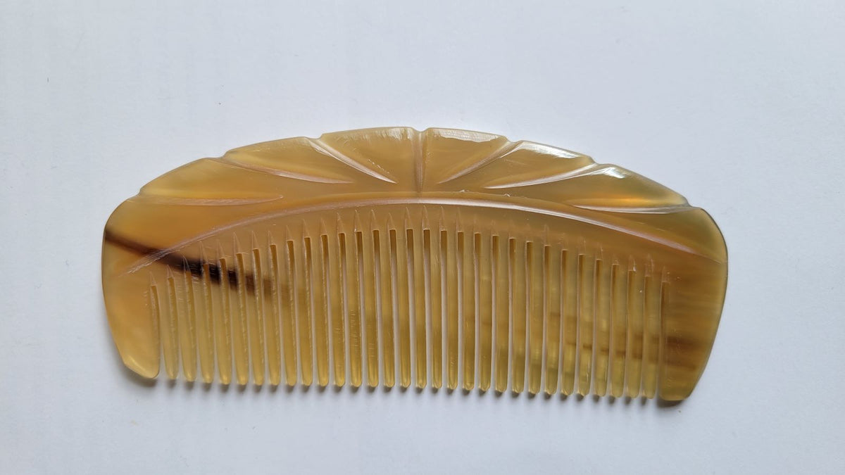 Translucent amber yak horn comb with Art Deco-influenced spine carving, warm golden tone, anti-static natural horn hair comb flat lay | Arakicrafts
